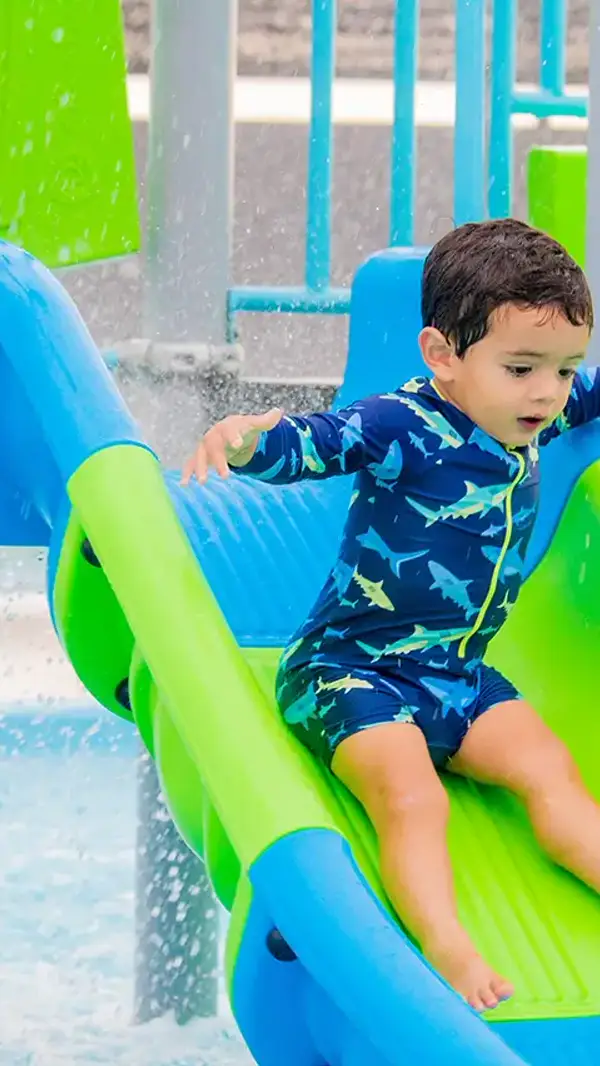 Niño bajando por un tobogán en la piscina infantil