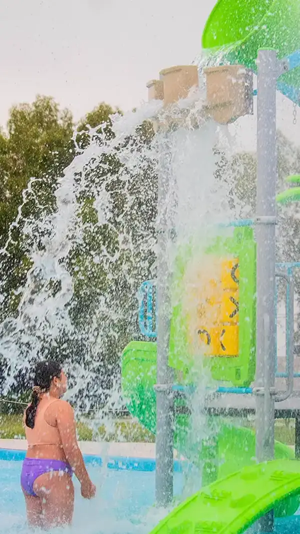 Chica bajo la cascada de los juegos de agua