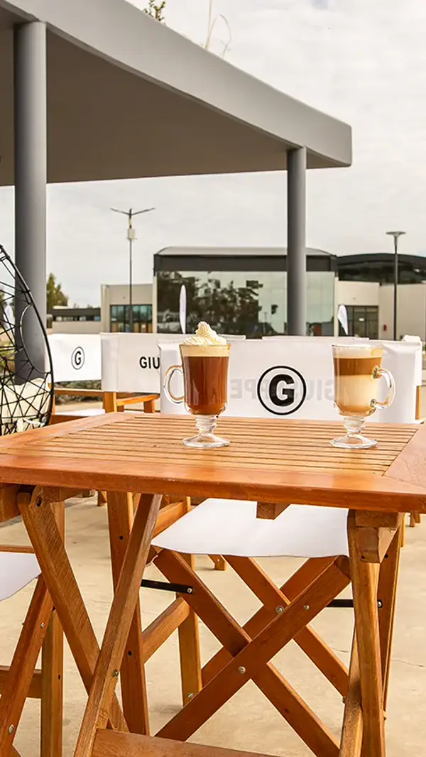 Café con crema en una mesa de madera del patio gastronómico